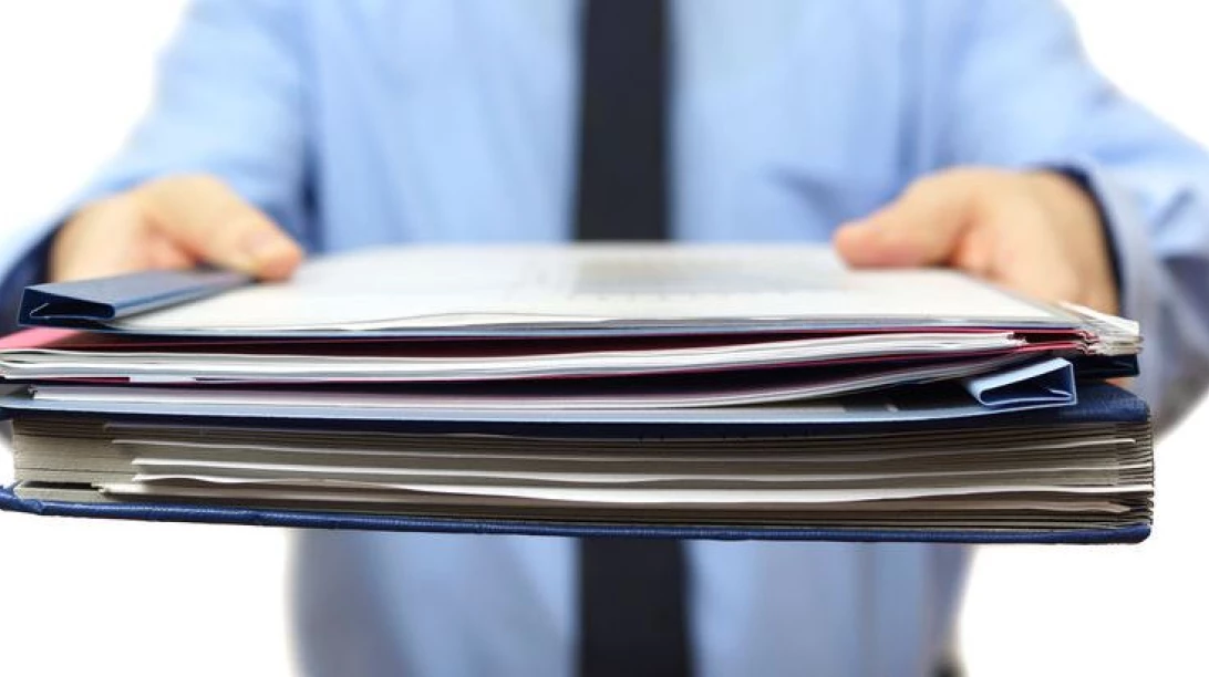 Image de quelqu'un en train de donner des documents à quelqu'un.