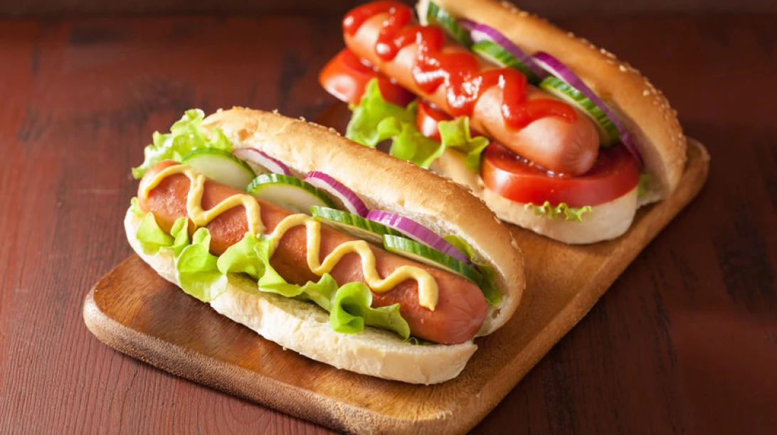 Deux hot-dogs sur une planche de bois.