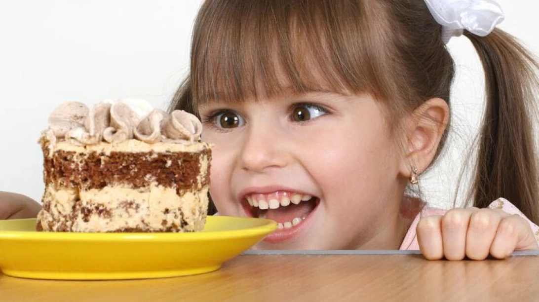 Enfant qui ressent l"envie de manger du gâteau.