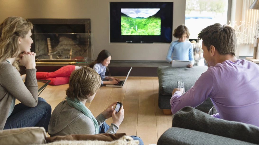 Famille en train de regarder leurs écrans.