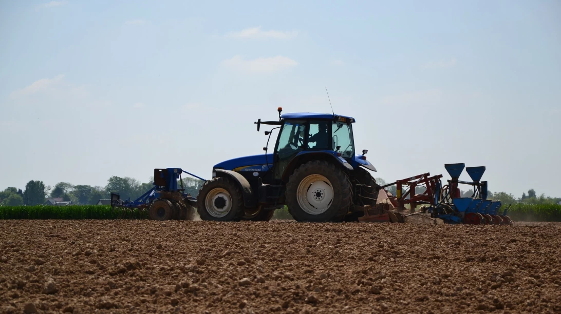 Photo d'un tracteur labourant une terrain.