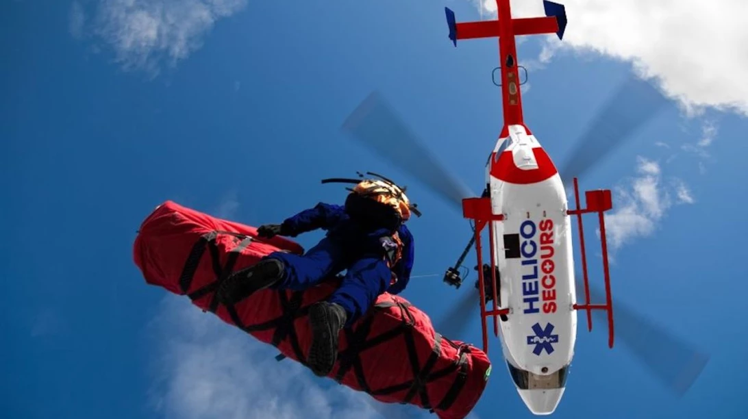 Secouriste qui descend d'un hélicoptère Helico Secours.