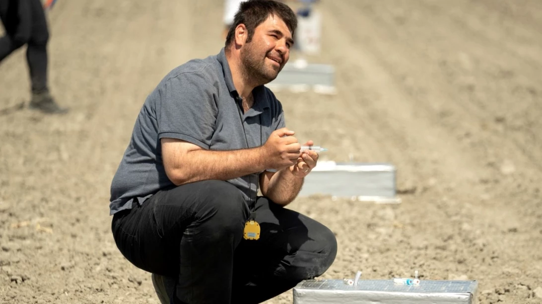 Personne accroupit dans un champ