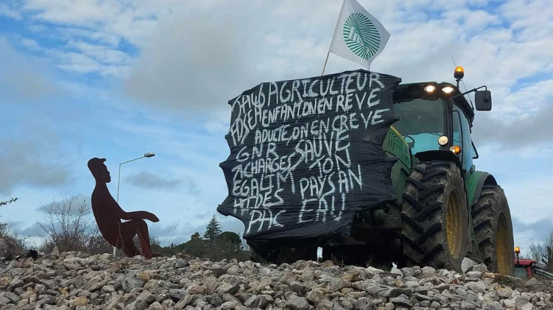 Tracteur français portant une pancarte de manifestation.