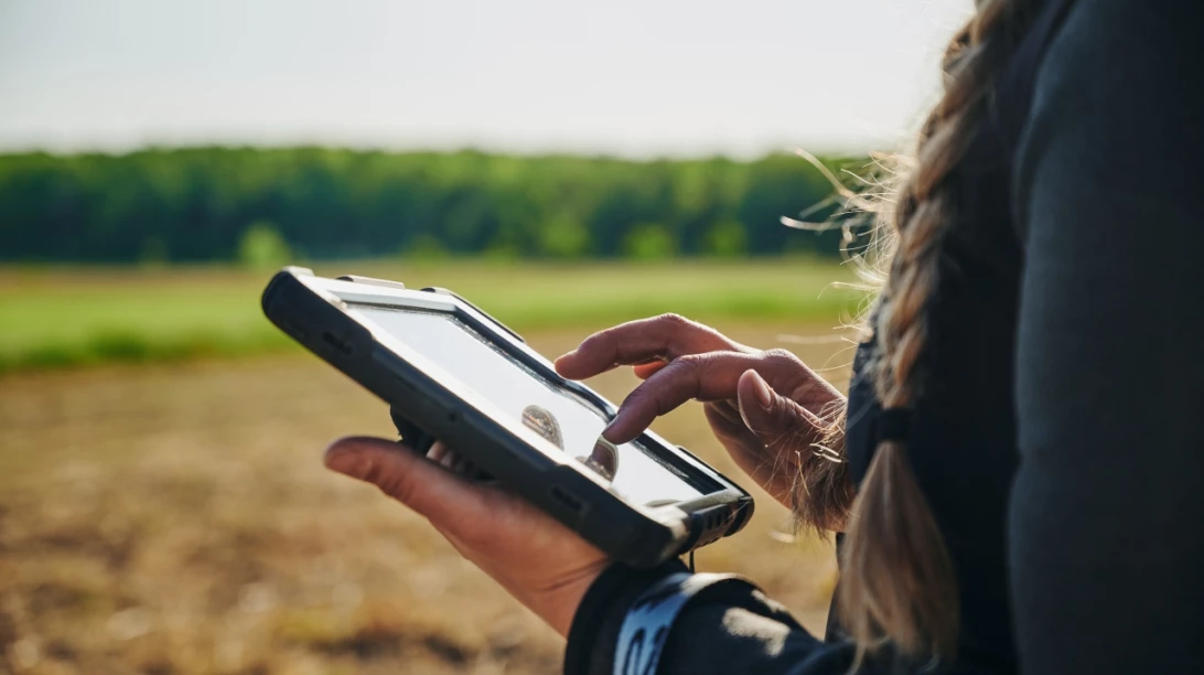 Femme dans un champ avec sa tablette