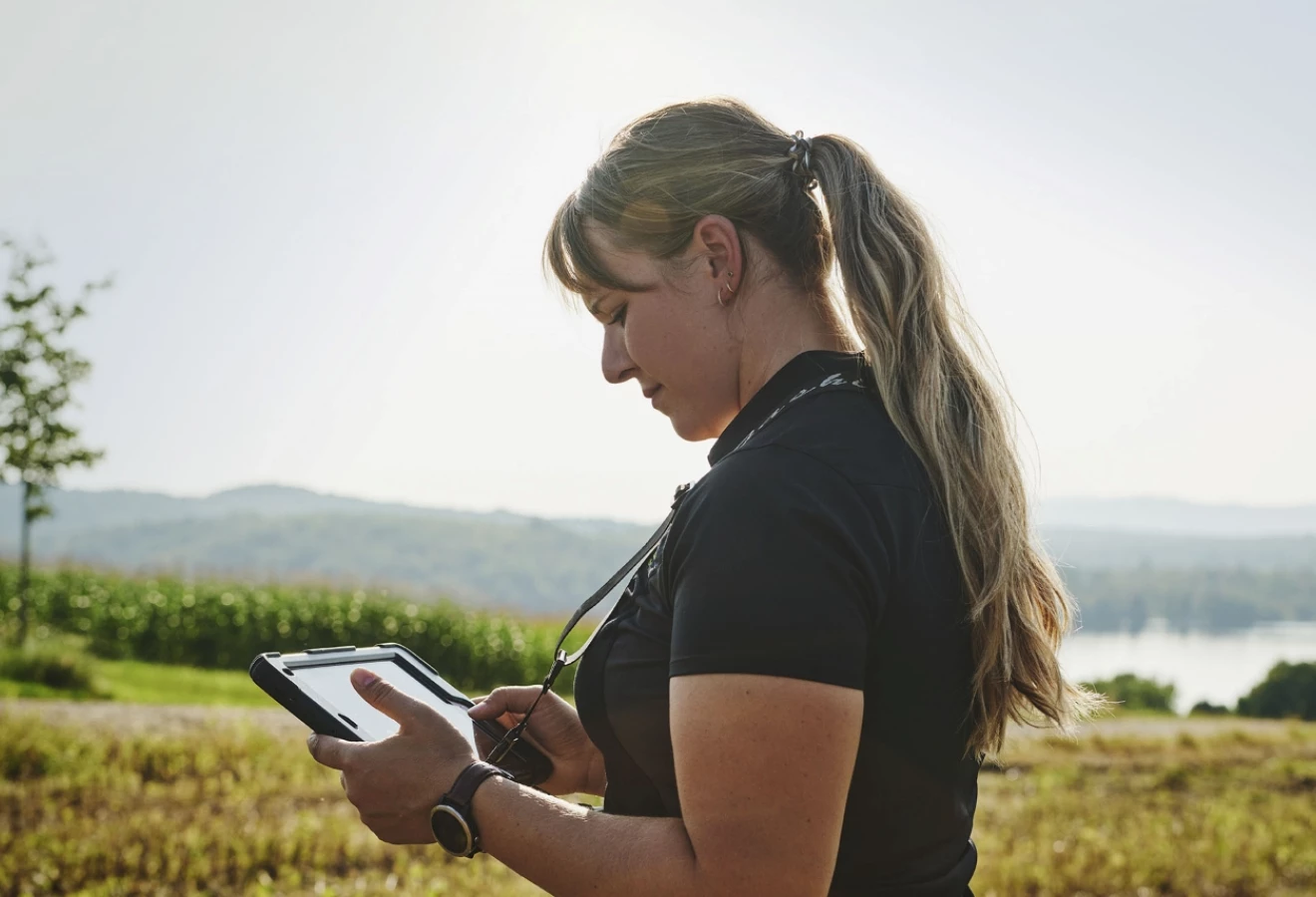 Une experte-conseil de Sollio Agriculture consule une tablette dans un champs