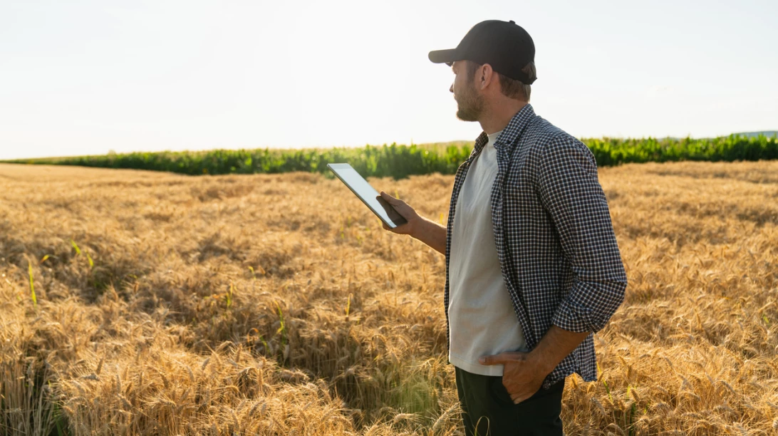 Homme dans un champ avec une tablette
