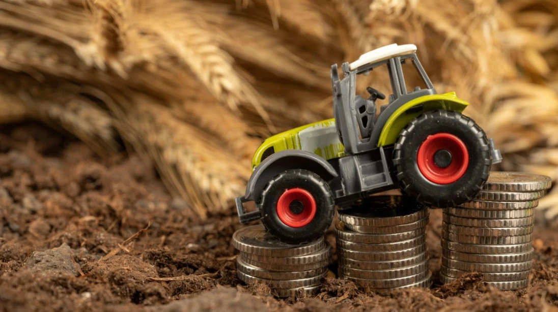 Tracteur jouet descendant sur une pile d'argent