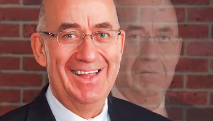 Photo de Jean-Paul Ouellet triste derrière une version de son visage qui sourie.