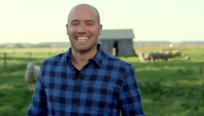 Stefano, l'animateur de l'émission Arrive en campagne, posant devant une ferme.