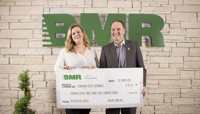 Chef de la direction du Groupe BMR en train de remettre un chèque.