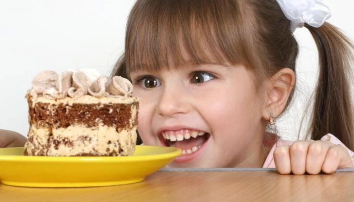 Enfant qui ressent l"envie de manger du gâteau.