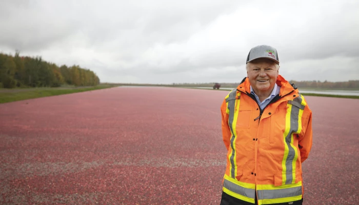 Marc Bieler, debout devant un champ de canneberges