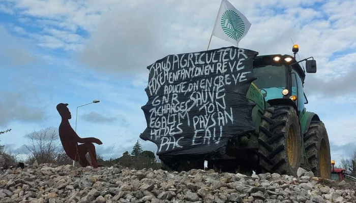 Tracteur français portant une pancarte de manifestation.