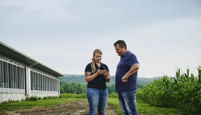 Deux personnes discutant près d'un bâtiment agricole