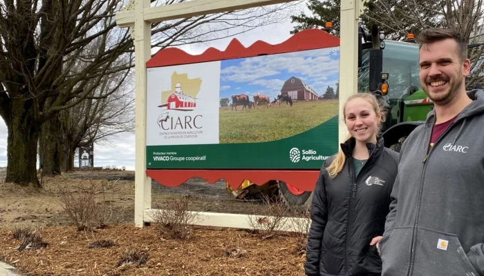 Lydia Charron, gérante du troupeau, et Anthony Laroche, agronome et directeur général, devant la pancarte du Centre d’initiatives en agriculture de la région de Coaticook (CIARC)
