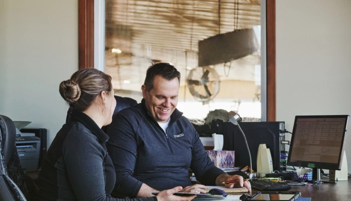 Couple de producteurs s'affairant à la planification des champs dans un bureau.