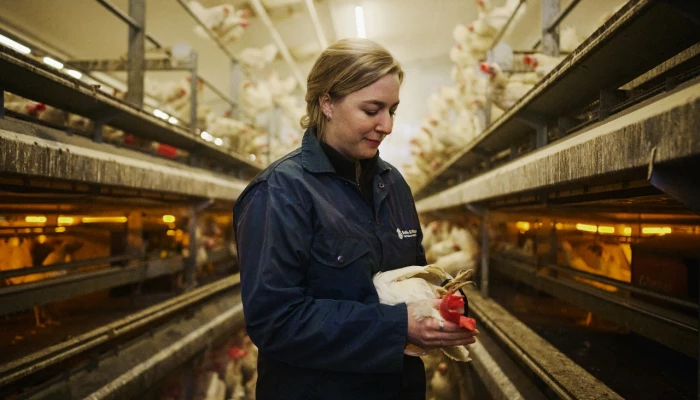 Experte-conseil de Sollio Agriculture tenant une poule pondeuse.