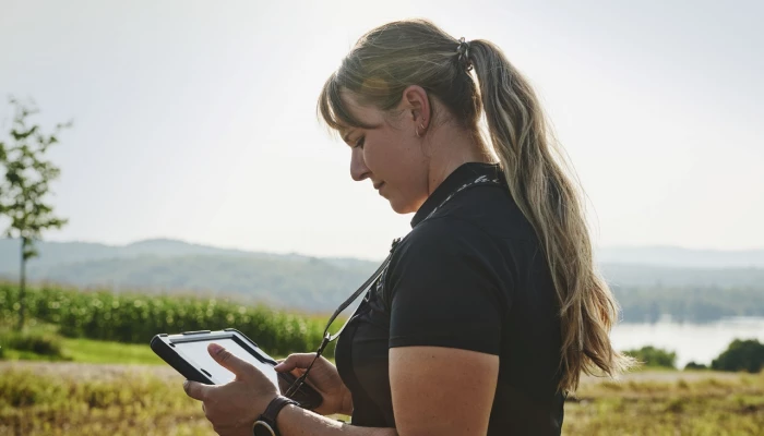 Une experte-conseil de Sollio Agriculture consule une tablette dans un champs