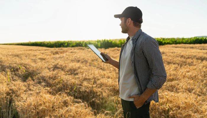 Homme dans un champ avec une tablette