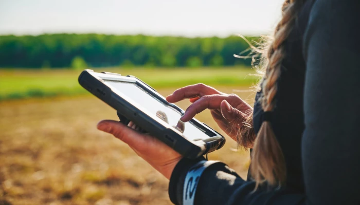 Femme utilisant une tablette dans un champ