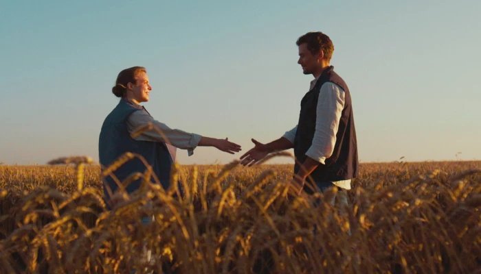 Deux personnes se serrant la main dans un champ
