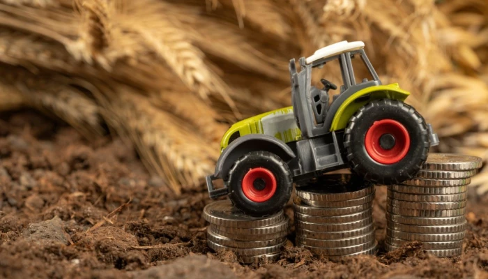 Tracteur jouet descendant sur une pile d'argent