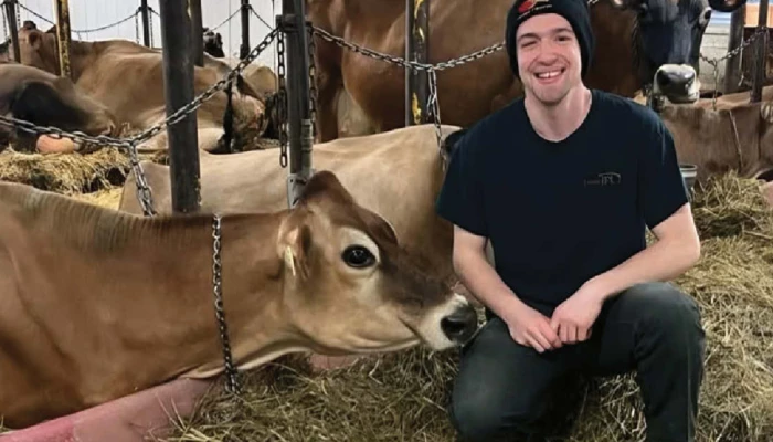Jérémy Boutin accroupi avec des vaches