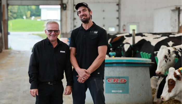 Guillaume Hinse et Mario Michaud, avec le robot repousse-fourrage de CRD