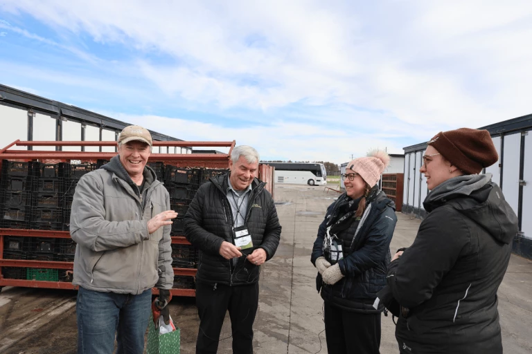 Brad Feth, Simon Baillargeon, Andréa Renaud et Emmanuelle Vincent discutent à côté des séchoirs de ginseng.