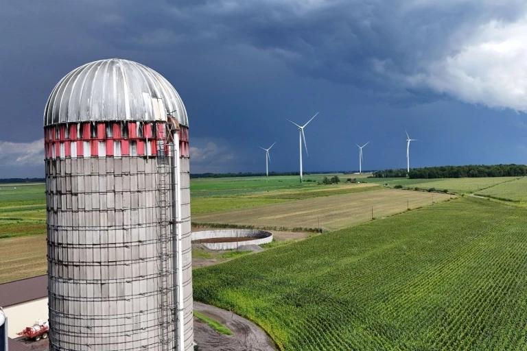 Silo devant des éoliennes